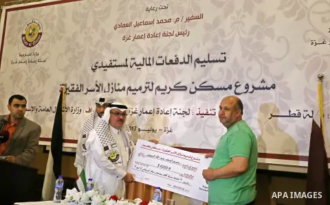 Qatar's Ambassador to the Palestinian Authority, Mohammed Al Emadi, delivers financial payments to the project to repair the homes of poor families, in Gaza city on July 10, 2017. Photo by Ashraf Amra