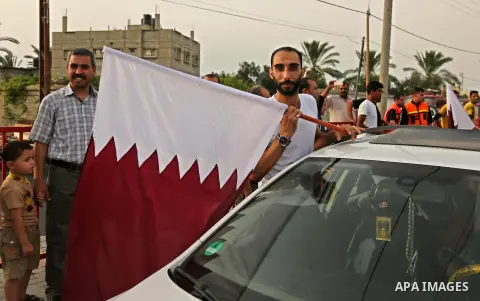 A Palestinian man waves the Qatar flag during the opening ceremony of rebuild Salah Al-Deen street project -Phase IV- funded by Qatar in al-Nusairat in the center of Gaza strip, on July 11, 2017. Photo by Ashraf Amra