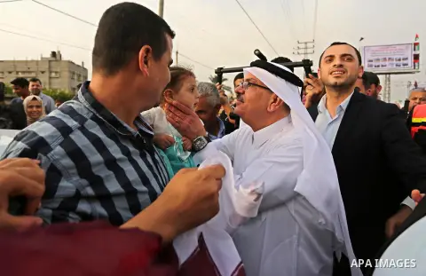Qatar's Ambassador to the Palestinian Authority, Mohammed Al Emadi kisses a Palestinian girl during the opening ceremony of rebuild Salah Al-Deen street project -Phase IV- funded by Qatar in al-Nusairat in the center of...