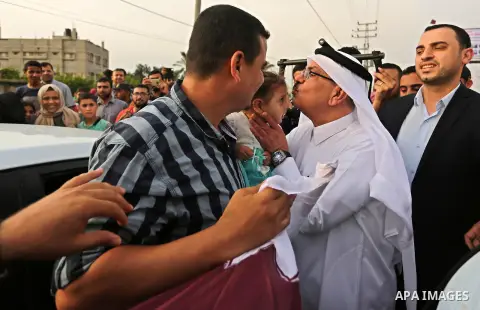 Qatar's Ambassador to the Palestinian Authority, Mohammed Al Emadi kisses a Palestinian girl during the opening ceremony of rebuild Salah Al-Deen street project -Phase IV- funded by Qatar in al-Nusairat in the center of...