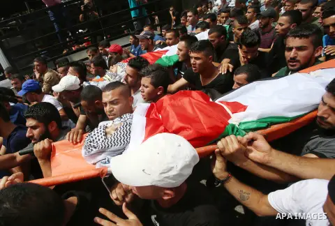 Palestinian mourners carry the bodies of 21-year-old Saad Salah during a funeral for Saad and 17-year-old Aws Salame, who were shot dead during clashes with the Israeli security forces in the West Bank city of Jenin, on...