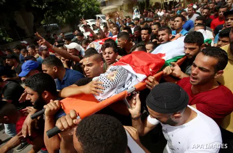 Palestinian mourners carry the bodies of 21-year-old Saad Salah during a funeral for Saad and 17-year-old Aws Salame, who were shot dead during clashes with the Israeli security forces in the West Bank city of Jenin, on...