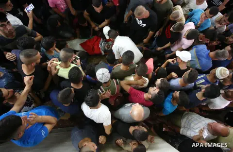 Relatives of 21-year-old Saad Salah mourn over his body during the funeral of Saad and 17-year-old Aws Salame, who were shot dead during clashes with the Israeli security forces in the West Bank city of Jenin, on July 12...