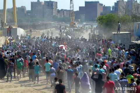 Egyptians gather during the operations of removal of illegal buildings which built on the state lands in the Warraq district of Giza, southwest of Cairo, Egypt, on July 16, 2017. Photo by Amr Sayed