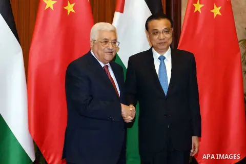 Palestinian President Mahmoud Abbas shakes hands with Chinese Prime Minister Li Keqiang before a meeting, in Beijing, China, on July 19, 2017. Abbas is on an official visit to China from July 17-20. Photo by Thaer Ganaim