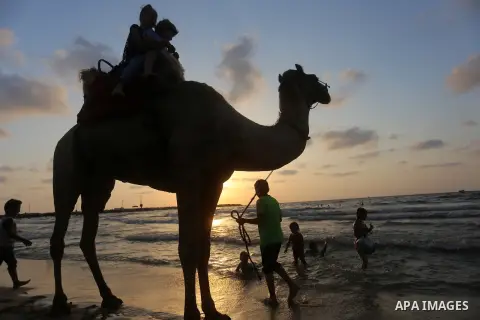 Palestinians enjoy their time at the beach of the Mediterranean sea on the coast of Gaza city on July 19, 2017. Photo by Yasser Qudih