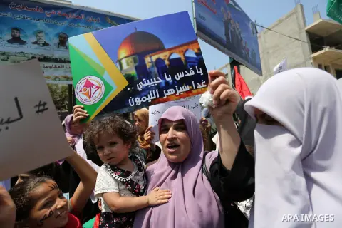 Palestinian protesters shout slogans and hold placards during a demonstration against Israeli security measures that were implemented at the Al-Aqsa mosque compound in Jerusalem the previous week prior to being removed a...