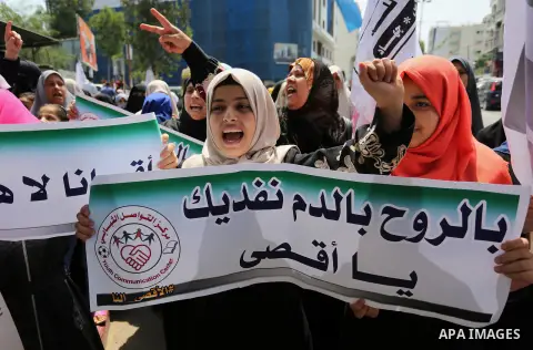 Palestinian protesters shout slogans and hold placards during a demonstration against Israeli security measures that were implemented at the Al-Aqsa mosque compound in Jerusalem the previous week prior to being removed a...