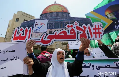 Palestinian protesters shout slogans and hold placards during a demonstration against Israeli security measures that were implemented at the Al-Aqsa mosque compound in Jerusalem the previous week prior to being removed a...