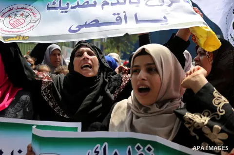 Palestinian protesters shout slogans and hold placards during a demonstration against Israeli security measures that were implemented at the Al-Aqsa mosque compound in Jerusalem the previous week prior to being removed a...