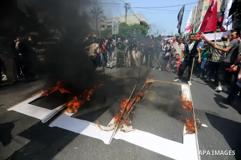Palestinian protesters burn models of metal detectors during a demonstration against Israeli security measures that were implemented at the Al-Aqsa mosque compound in Jerusalem the previous week prior to being removed af...
