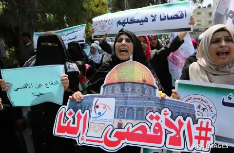 Palestinian protesters shout slogans and hold placards during a demonstration against Israeli security measures that were implemented at the Al-Aqsa mosque compound in Jerusalem the previous week prior to being removed a...
