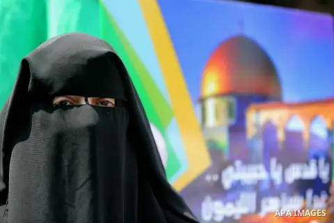 A masked female protester takes part during a demonstration against Israeli security measures that were implemented at the Al-Aqsa mosque compound in Jerusalem the previous week prior to being removed after their install...