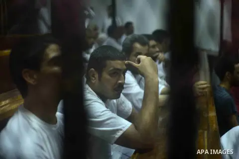Egyptian defendants sits behind the defendant's bars during their trial at "Cabinet Incidents" case at the court in Cairo, Egypt, on July 25, 2017. An Egyptian criminal court sentenced 43 activists to life in prison on T...