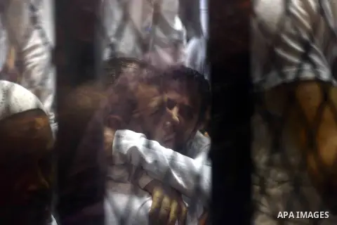 Egyptian defendants sits behind the defendant's bars during their trial at "Cabinet Incidents" case at the court in Cairo, Egypt, on July 25, 2017. An Egyptian criminal court sentenced 43 activists to life in prison on T...