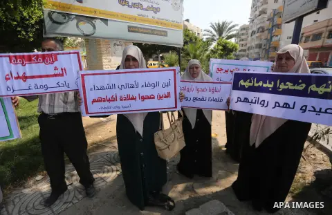 Palestinian Martyrs Families hold placards during a protest demanding their salaries in Gaza city on July 26, 2017. Photo by Mohammed Asad