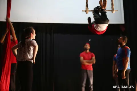 An Irish trainer, Jennifer Higgins, helps a member of Gaza circus to perform during an aerial silks practice class in Gaza City, on August 3, 2017. Photo by Mohammed Asad