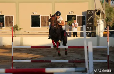 A Palestinian boy rides his horse during a jump obstacles championship, in Gaza city on August 4, 2017. Photo by Mohammed Asad
