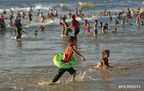 Palestinians enjoy their time at the beach of the Mediterranean sea on the coast of Gaza city on August 4, 2017. Photo by Ashraf Amra