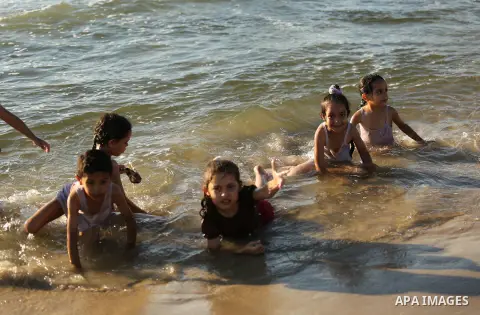 Palestinians enjoy their time at the beach of the Mediterranean sea on the coast of Gaza city on August 4, 2017. Photo by Ashraf Amra
