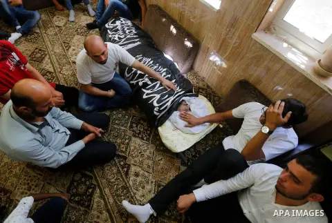 Palestinians mourn around the body of Palestinian Rafat Herbawi who had been killed in July 19 by Israeli soldiers after allegedly attempting car- ramming attack during his funeral in the West Bank of Hebron, on August 5...