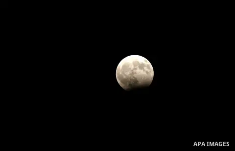 The moon goes into lunar eclipse as seen from the West Bank city of Hebron on August 07, 2018. The eclipse coincided with the moon being at it's closest point to earth on it's elliptical orbit. Photo by Wisam Hashlamoun