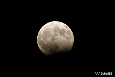 The moon goes into lunar eclipse as seen from the West Bank city of Hebron on August 07, 2018. The eclipse coincided with the moon being at it's closest point to earth on it's elliptical orbit. Photo by Wisam Hashlamoun