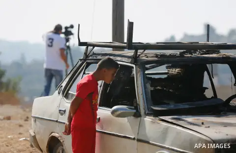 Palestinians from the village of Umm Safa, west of Ramallah in the occupied West Bank, check a vehicle that was set ablaze on August 9, 2017 after Israeli settlers reportedly vandalised the Palestinian village calling fo...