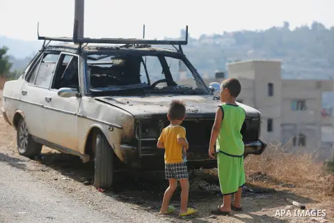 Palestinians from the village of Umm Safa, west of Ramallah in the occupied West Bank, check a vehicle that was set ablaze on August 9, 2017 after Israeli settlers reportedly vandalised the Palestinian village calling fo...