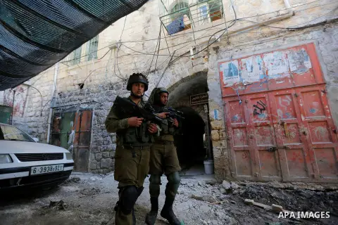 Israeli troops patrol a street in the West Bank city of Hebron, on August 10, 2017. Israeli authorities have demolished three homes and sealed off a fourth of Palestinians who carried out attacks that killed a soldier an...