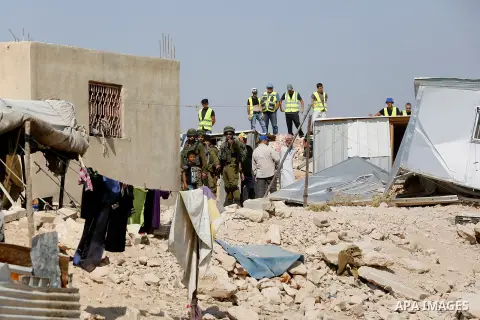 Workers empty EU donated houses in the Palestinian bedouin village of Khashm al-Daraj in the southern area of Yatta, south of the West Bank city of Hebron, on August 14, 2017. Photo by Wisam Hashlamoun