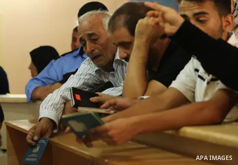 Palestinians wait for travel permits to cross into Egypt through the Rafah border crossing after it was opened by Egyptian authorities for humanitarian cases, in Rafah in the southern Gaza Strip on August 16, 2017. Photo...