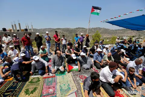 Palestinians take part in Friday prayer before a protest against alerts of the Israeli army to demolish houses, in the West Bank village of Walajeh, near Bethlehem, August 18, 2017. Photo by Wisam Hashlamoun