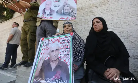 Palestinian hold banners during a protest to show solidarity with Palestinian Prisoner held in Israeli jails, in front of Red cross office, in Gaza city on August 21, 2017. Photo by Mohammed Asad