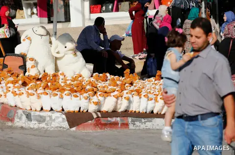 A Palestinian vendor displays toys of sheep at a market ahead of the Eid al-Adha festival in the West Bank city of Hebron, on August 21, 2017. Photo by Wisam Hashlamoun