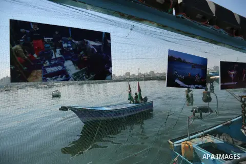 Palestinians attend a photo gallery on fishing boat, in Gaza seaport, on August 23, 2017. Photo by Ashraf Amra