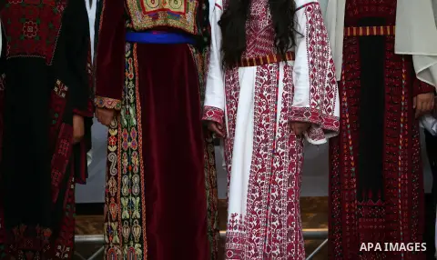 Palestinian women wearing traditional dress creation take part during a fashion show marking Traditional Palestinian Dress Day, in the West Bank city of Nablus on August 22, 2017. Photo by Ayman Ameen
