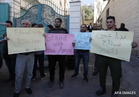 Supporters of Issa Amro, a prominent Palestinian activist and founder of Youth Against Settlements, protest outside the court in the West Bank town of Hebron on September 7, 2017, after he was detained for criticising th...