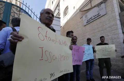 Supporters of Issa Amro, a prominent Palestinian activist and founder of Youth Against Settlements, protest outside the court in the West Bank town of Hebron on September 7, 2017, after he was detained for criticising th...