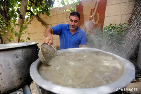 A Palestinian farmer prepares the grape juice at his field near the West Bank city of Hebron, Sept. 14, 2017. Hebron is famous for its quality grape production and its lush vineyards. Photo by Wisam Hashlamoun