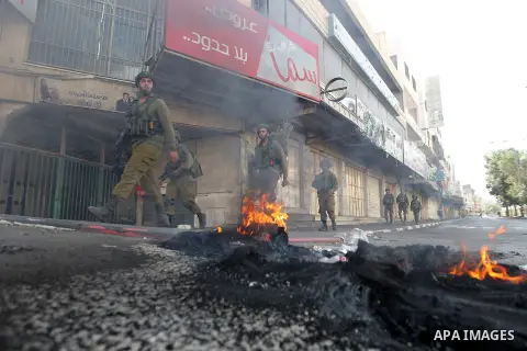 Israeli soldiers take position during a protest by Palestinians against closure of a road south of the West Bank city of Hebron September 22, 2017. Photo by Wisam Hashlamoun