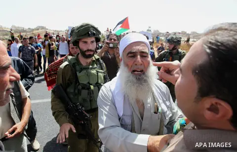 Palestinians take part in a protest against closure of a road by Israeli troops south of the West Bank city of Hebron September 22, 2017. Photo by Wisam Hashlamoun