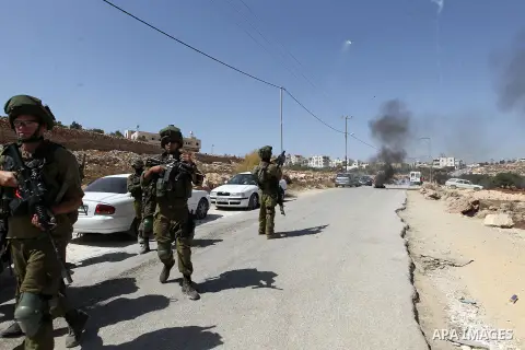 Israeli soldiers take position during a protest by Palestinians against closure of a road south of the West Bank city of Hebron September 22, 2017. Photo by Wisam Hashlamoun