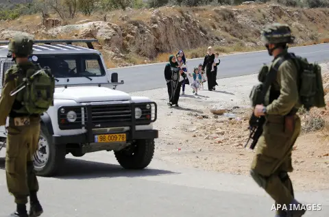 Israeli soldiers take position during a protest by Palestinians against closure of a road south of the West Bank city of Hebron September 22, 2017. Photo by Wisam Hashlamoun