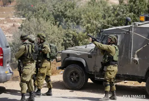 Israeli soldiers take position during a protest by Palestinians against closure of a road south of the West Bank city of Hebron September 22, 2017. Photo by Wisam Hashlamoun