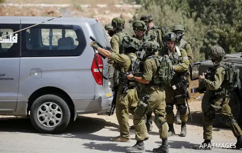 Israeli soldiers take position during a protest by Palestinians against closure of a road south of the West Bank city of Hebron September 22, 2017. Photo by Wisam Hashlamoun