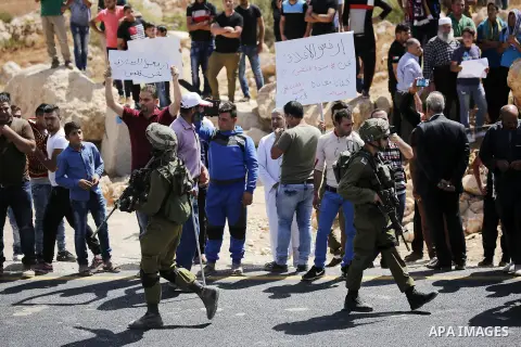 Palestinians take part in a protest against closure of a road by Israeli troops south of the West Bank city of Hebron September 22, 2017. Photo by Wisam Hashlamoun