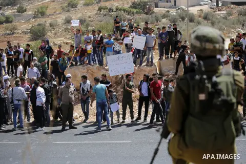 Palestinians take part in a protest against closure of a road by Israeli troops south of the West Bank city of Hebron September 22, 2017. Photo by Wisam Hashlamoun