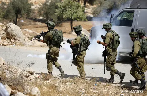 Israeli soldiers take position during a protest by Palestinians against closure of a road south of the West Bank city of Hebron September 22, 2017. Photo by Wisam Hashlamoun