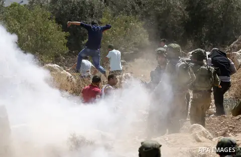 Palestinian run for cover from sound grenades during clashes following a protest against closure of a road south of the West Bank city of Hebron September 22, 2017. Photo by Wisam Hashlamoun